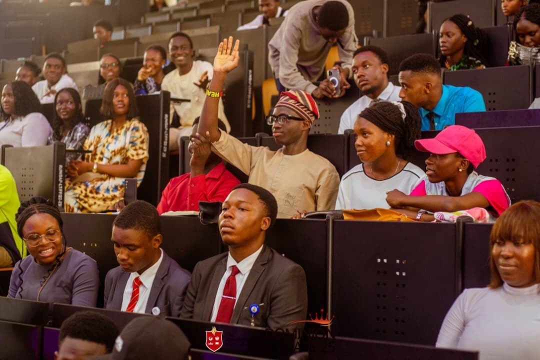 Young people attending The Dominion Mandate Conference, one raising a hand to ask a question